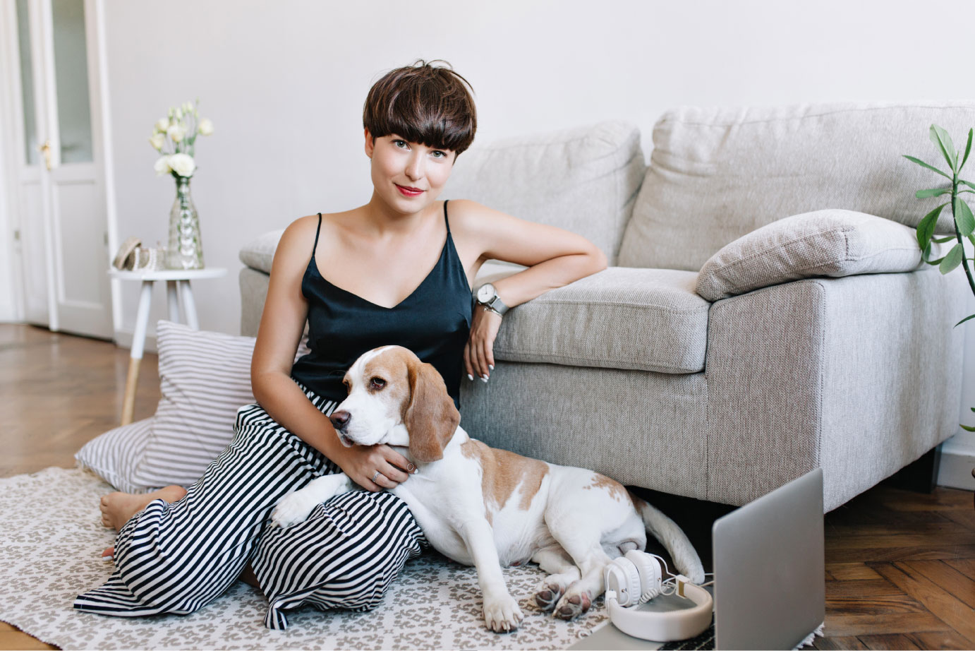 incredible-brunette-lady-wears-elegant-wristwatch-posing-beside-sofa-stroking-cute-beagle